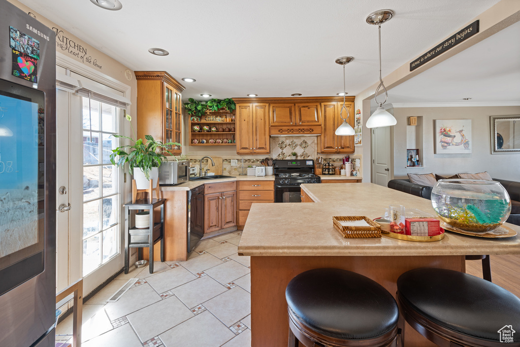 Kitchen featuring open shelves, a sink, light countertops, brown cabinets, and black appliances