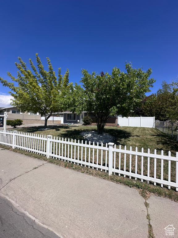 Obstructed view of property featuring a fenced front yard and a front yard