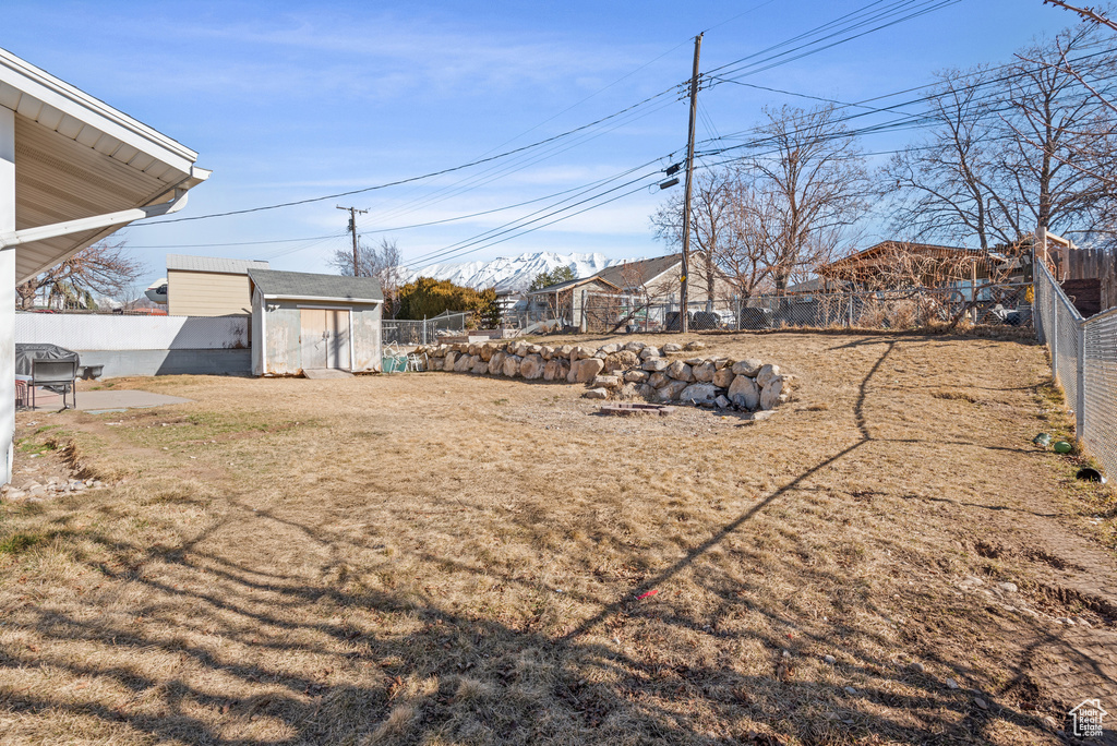 View of yard featuring an outbuilding and fence