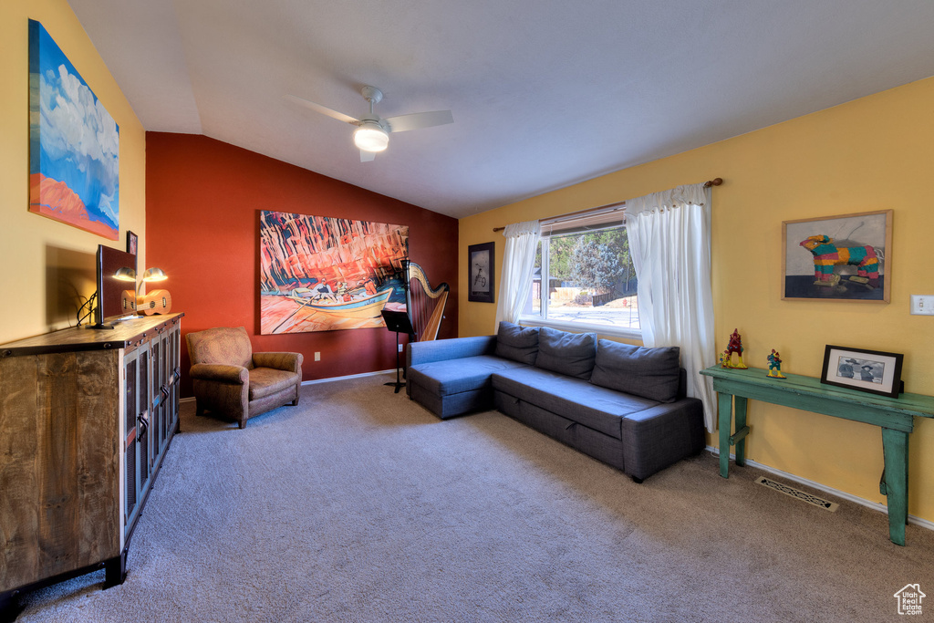 Living room with carpet flooring, lofted ceiling, a ceiling fan, and baseboards