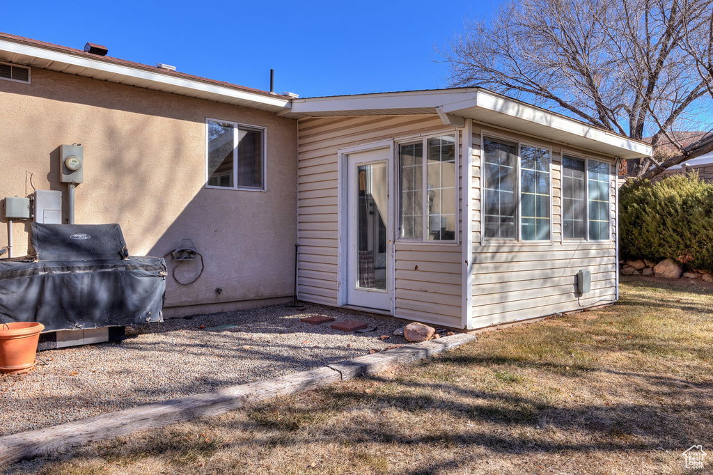 Back of property featuring stucco siding and a lawn