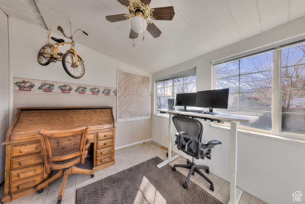 Office area with lofted ceiling, light tile patterned floors, and a ceiling fan
