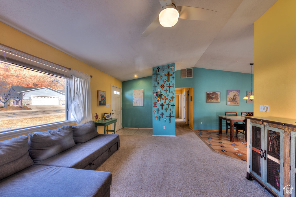 Living area featuring lofted ceiling, a ceiling fan, carpet floors, and baseboards
