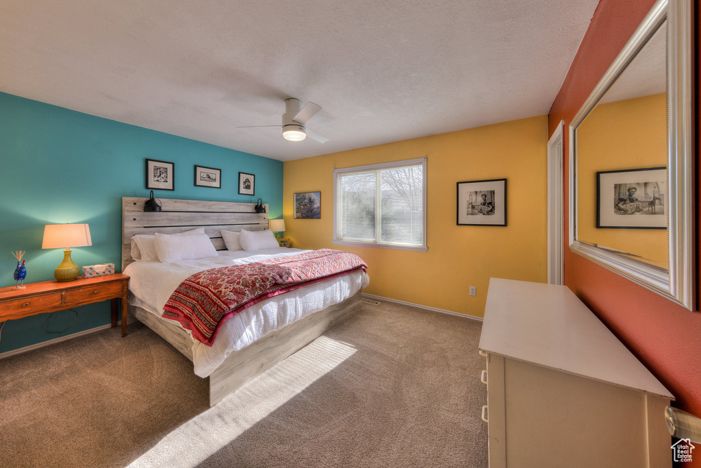 Carpeted bedroom featuring baseboards and ceiling fan