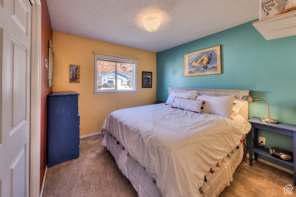 Bedroom featuring carpet and baseboards