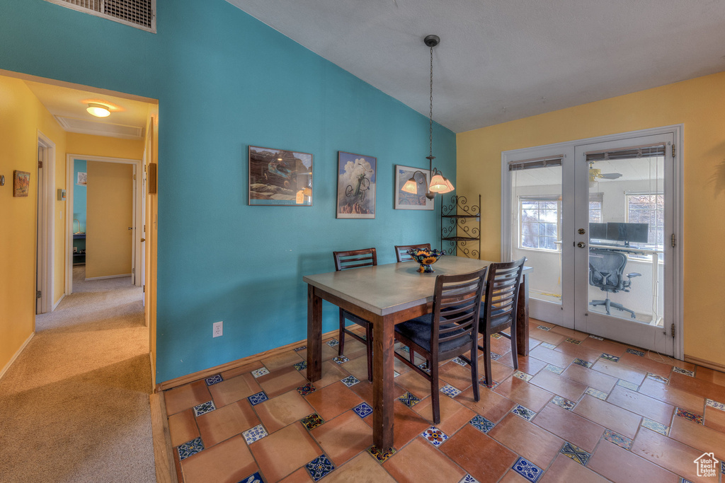 Dining room featuring lofted ceiling, baseboards, and a chandelier
