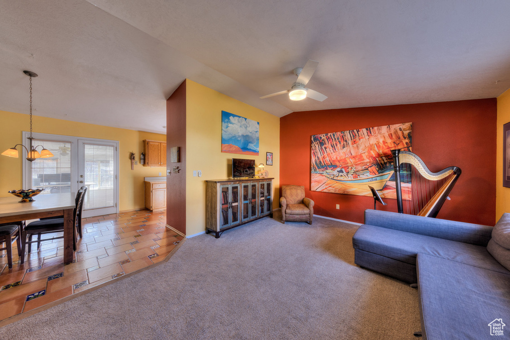 Carpeted living room featuring a ceiling fan and baseboards