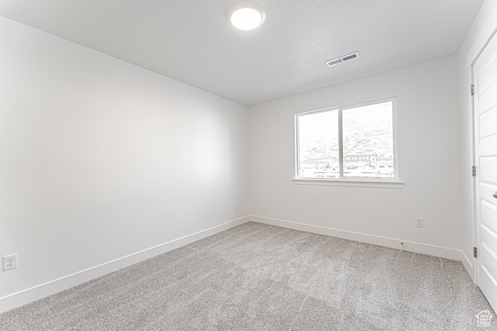 Unfurnished bedroom featuring carpet, baseboards, and a textured ceiling
