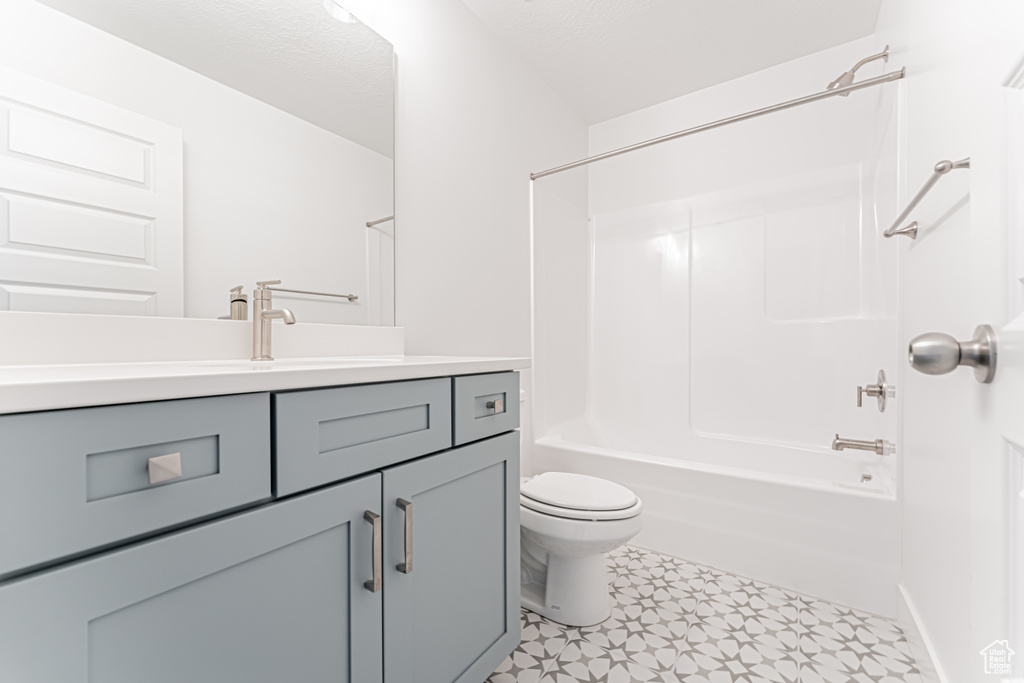 Bathroom with vanity, toilet,  shower combination, and tile patterned floors