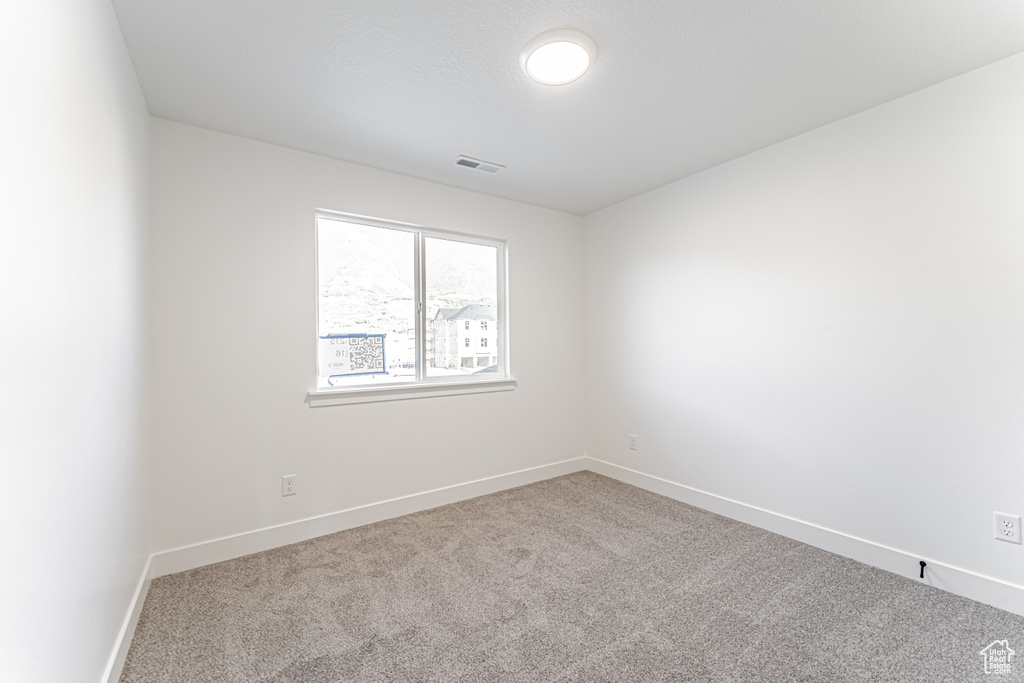 Carpeted empty room with baseboards