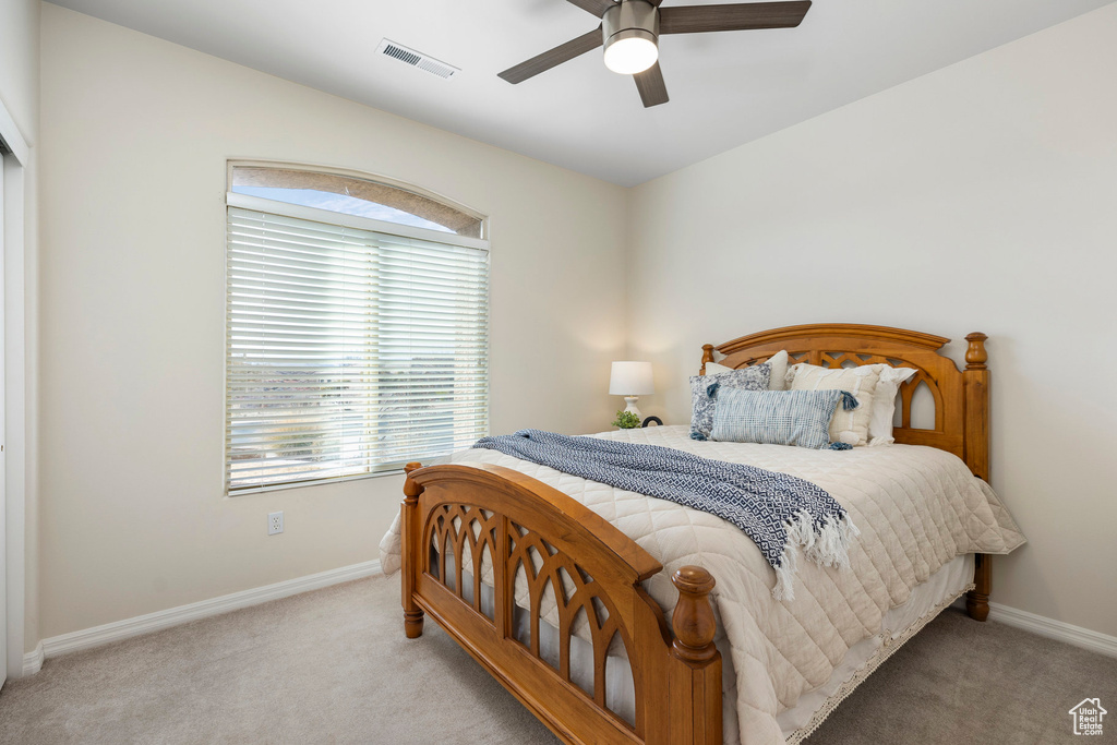 Carpeted bedroom featuring baseboards and a ceiling fan