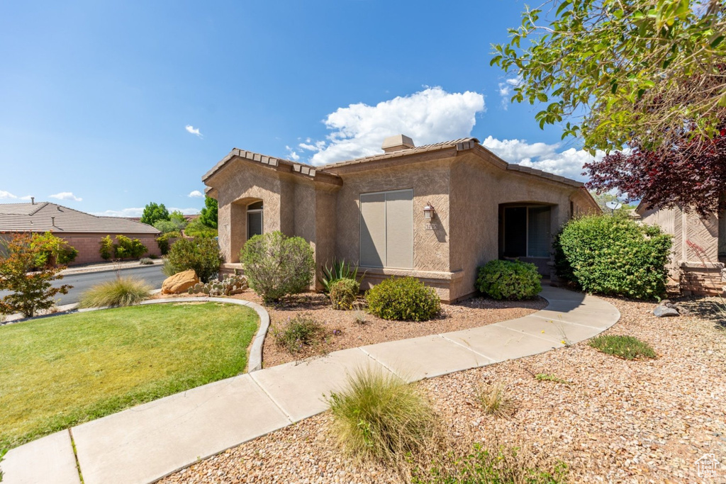 View of front facade featuring stucco siding and a front lawn