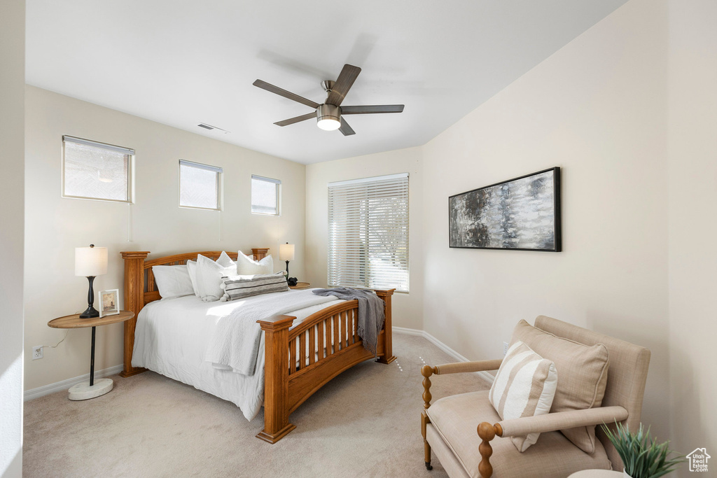 Bedroom with light carpet, baseboards, and a ceiling fan