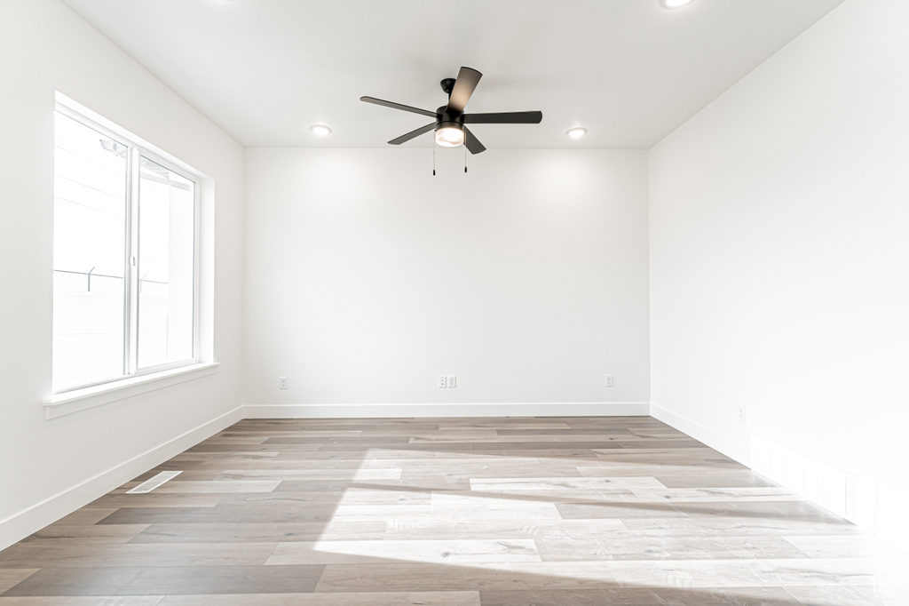 Empty room featuring a ceiling fan, recessed lighting, and light wood-style floors