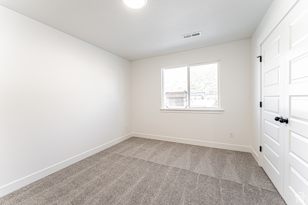 Carpeted empty room featuring baseboards