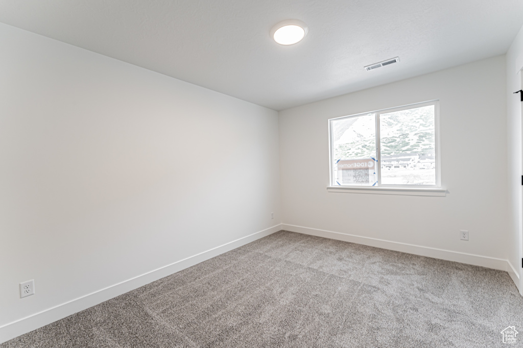 Unfurnished room featuring light colored carpet and baseboards