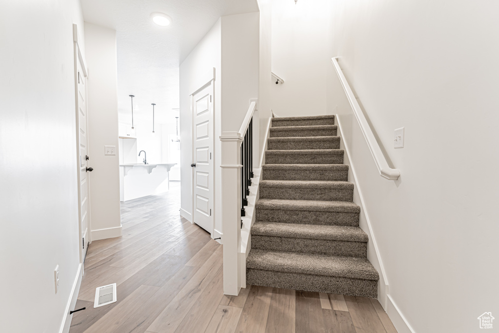 Stairs featuring wood finished floors