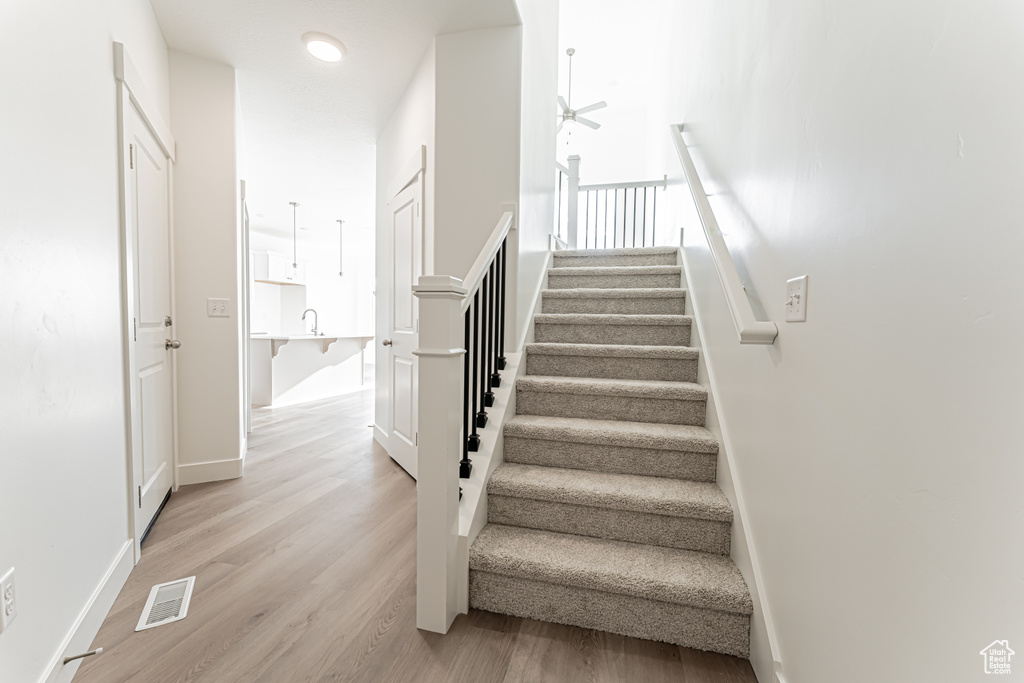 Staircase with wood finished floors and baseboards