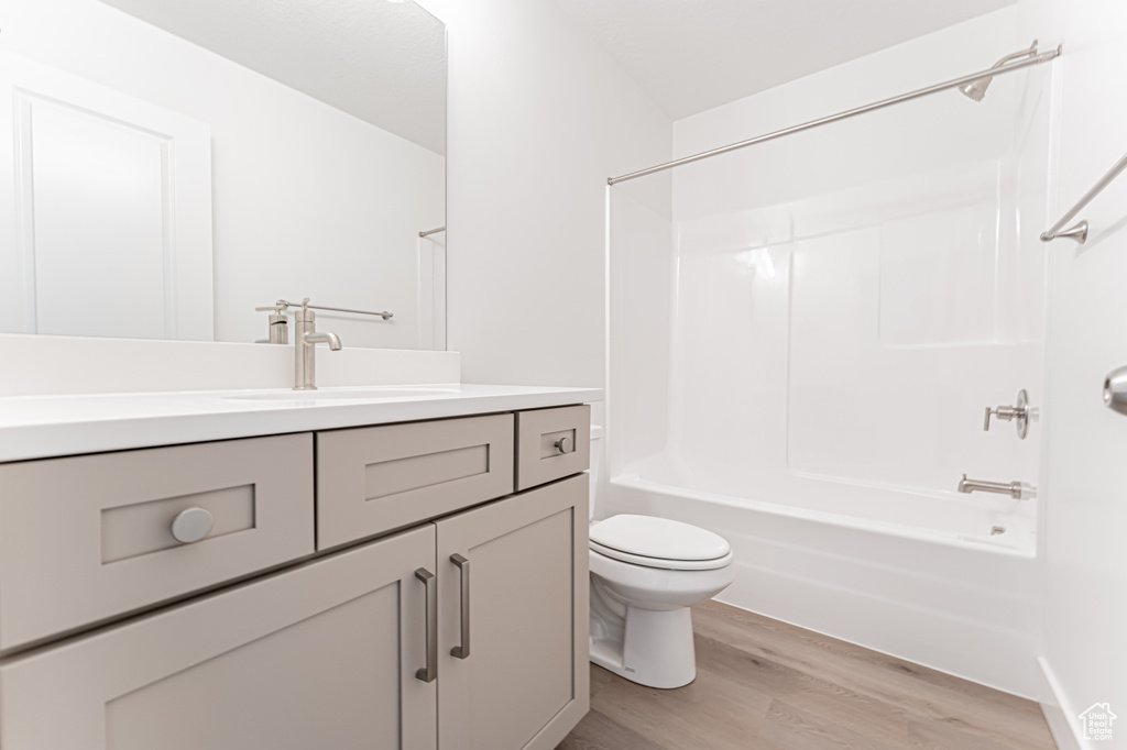Full bath featuring wood finished floors, vanity, toilet, and shower / bathtub combination