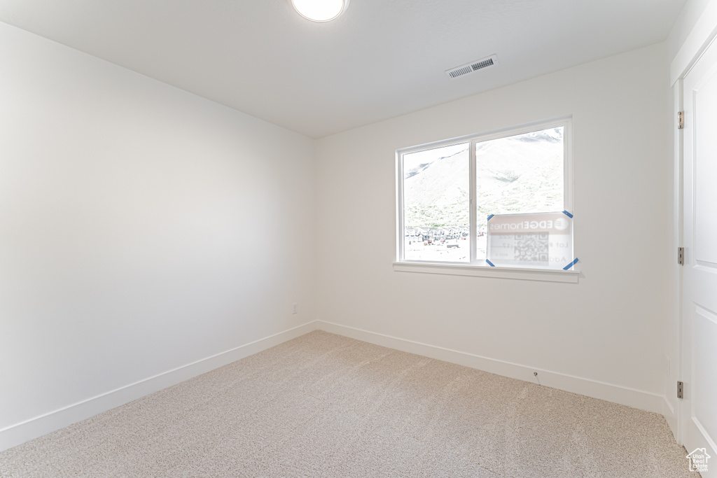 Unfurnished room featuring light colored carpet and baseboards