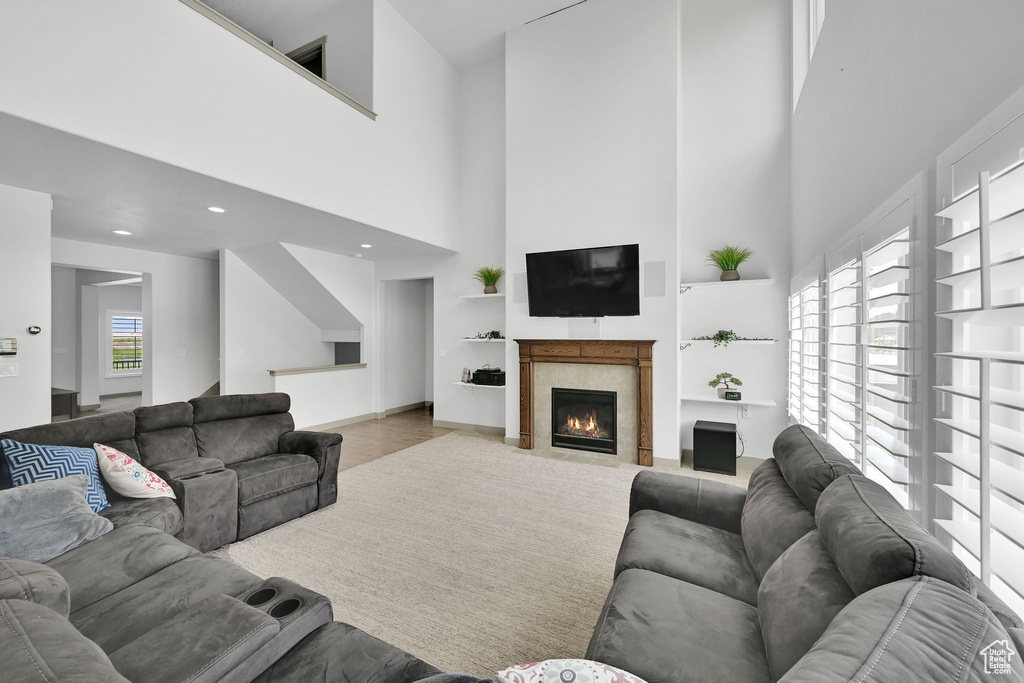 Living room featuring a tiled fireplace and a high ceiling
