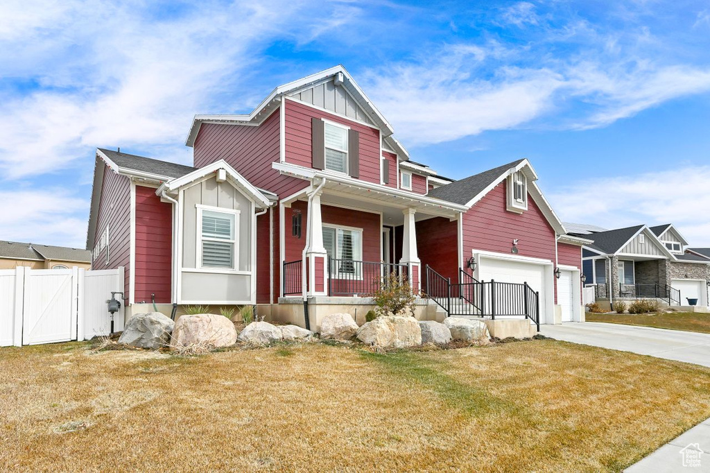 Craftsman-style home featuring a garage, a front yard, and covered porch