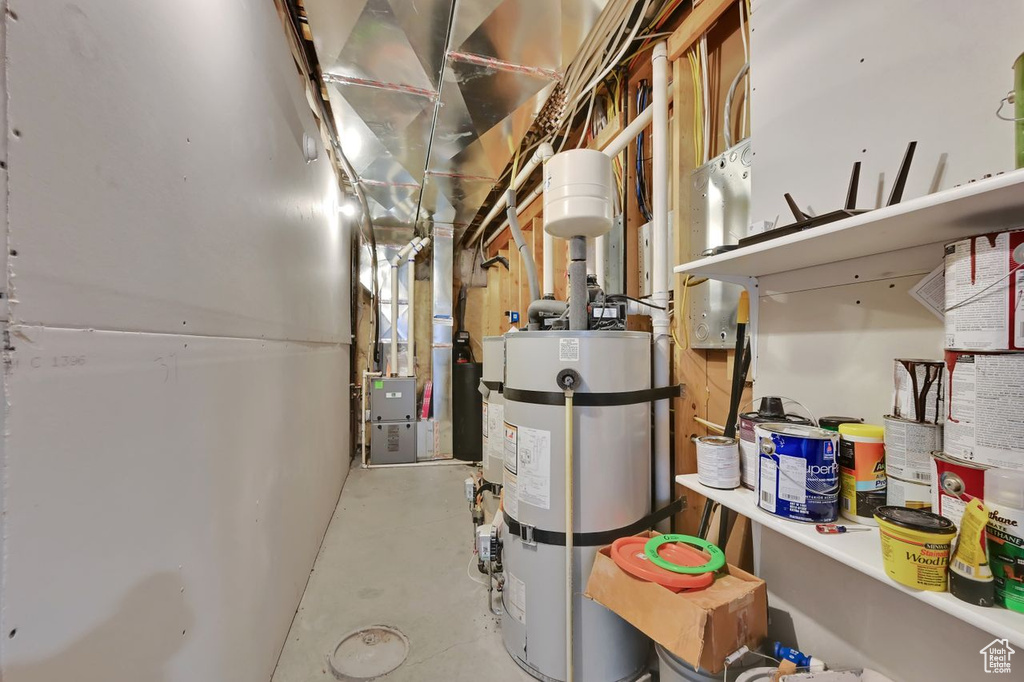 Utility room featuring heating unit and secured water heater