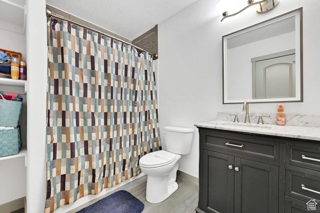 Bathroom featuring vanity, toilet, and a shower with shower curtain