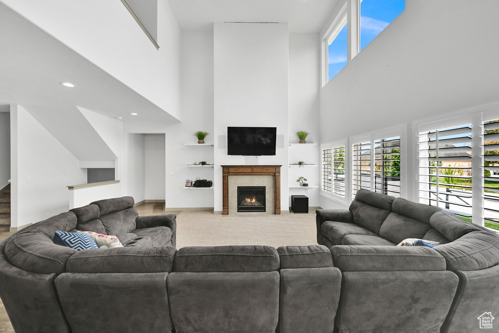 Living area featuring a towering ceiling, a wealth of natural light, and a fireplace