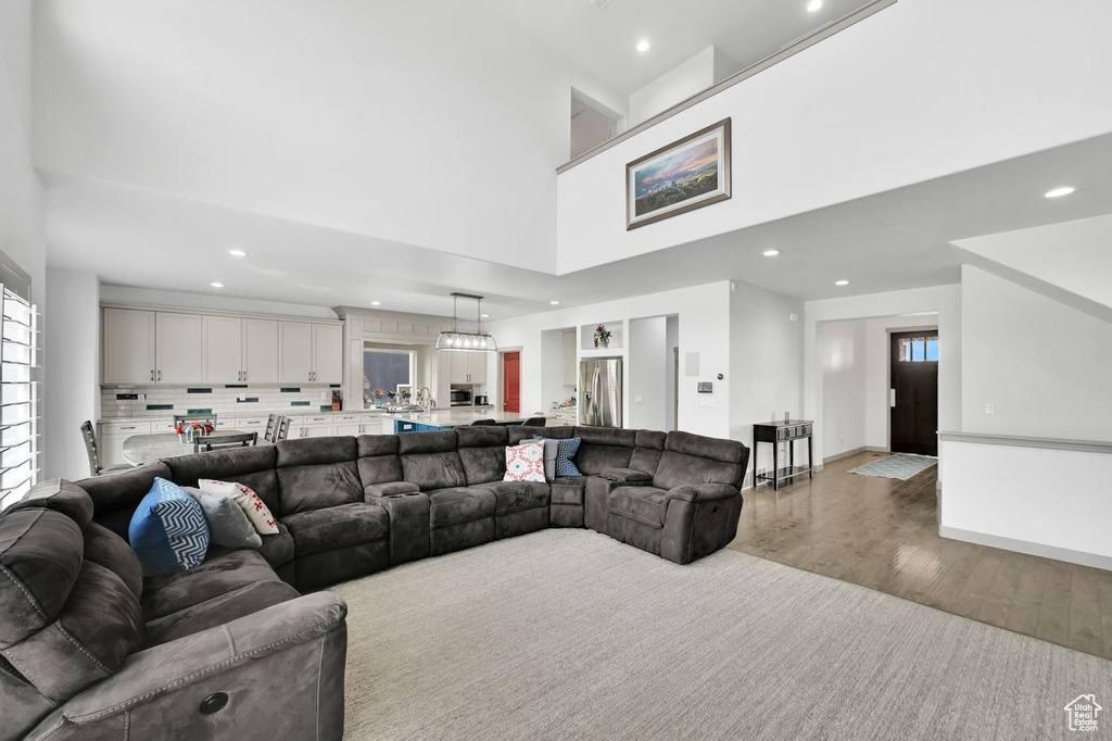 Living room featuring a towering ceiling and light hardwood / wood-style flooring