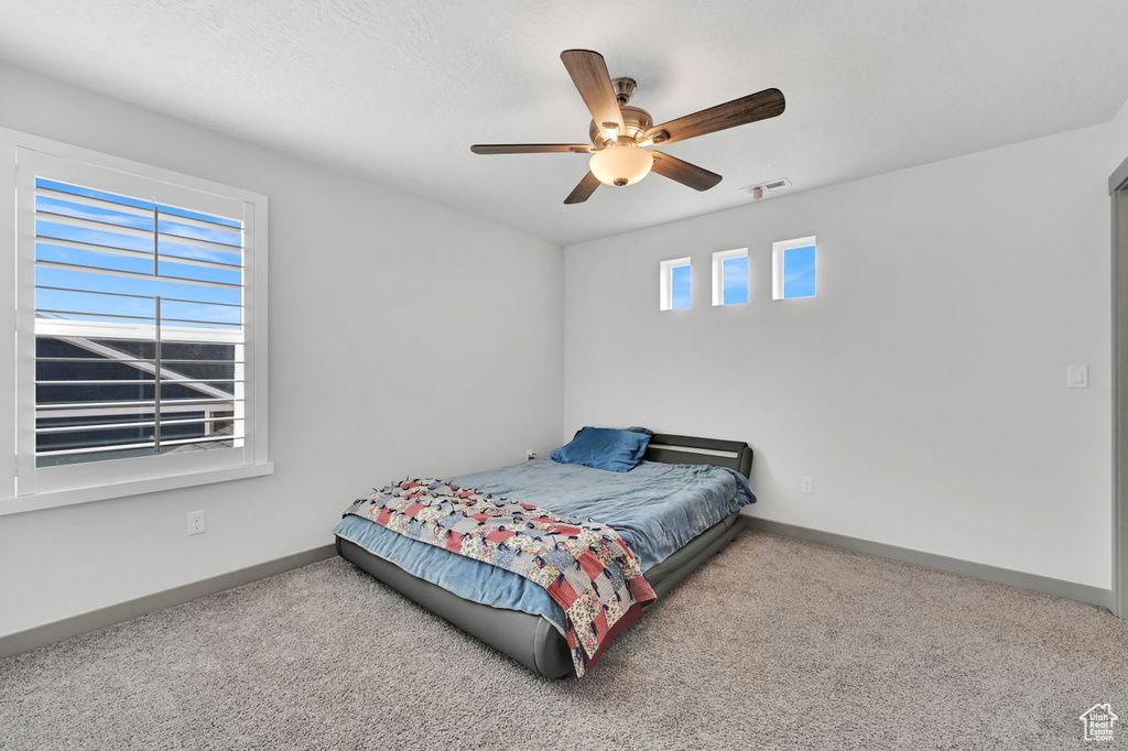 Bedroom featuring ceiling fan and carpet floors