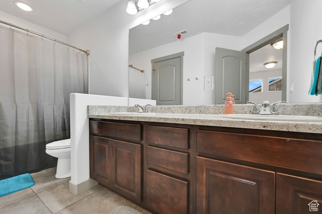 Bathroom with tile patterned floors, vanity, and toilet