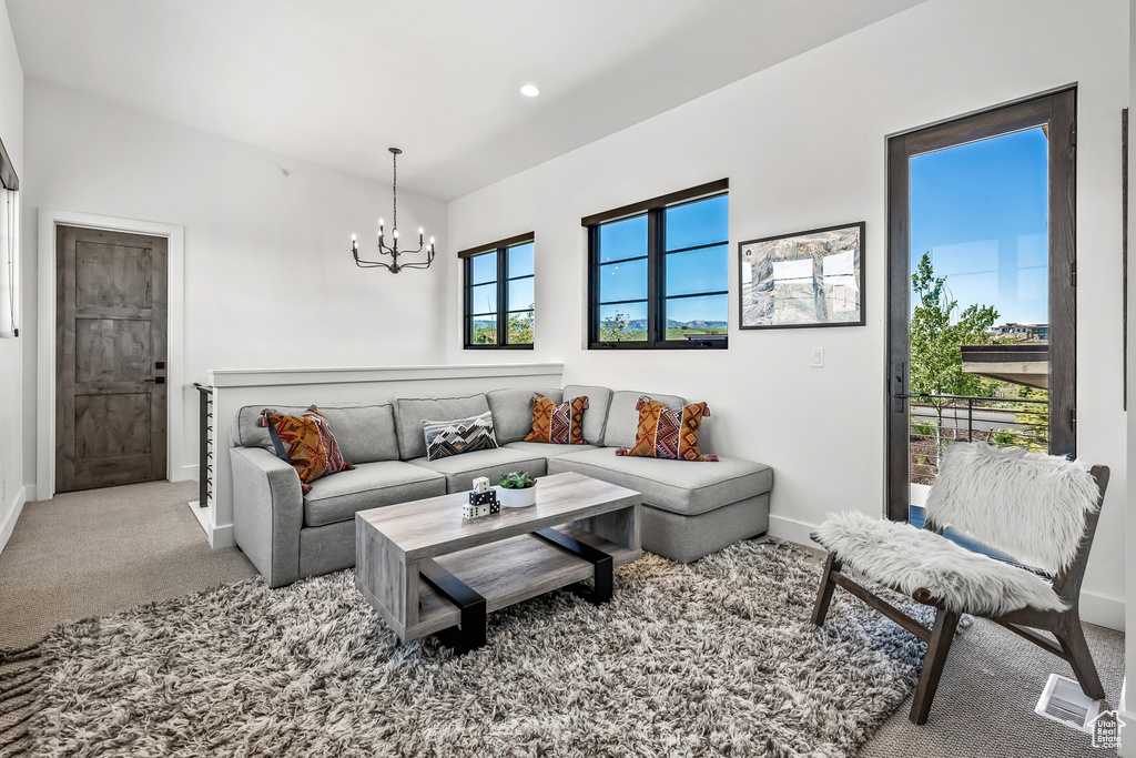 Carpeted living area featuring recessed lighting, a chandelier, and baseboards