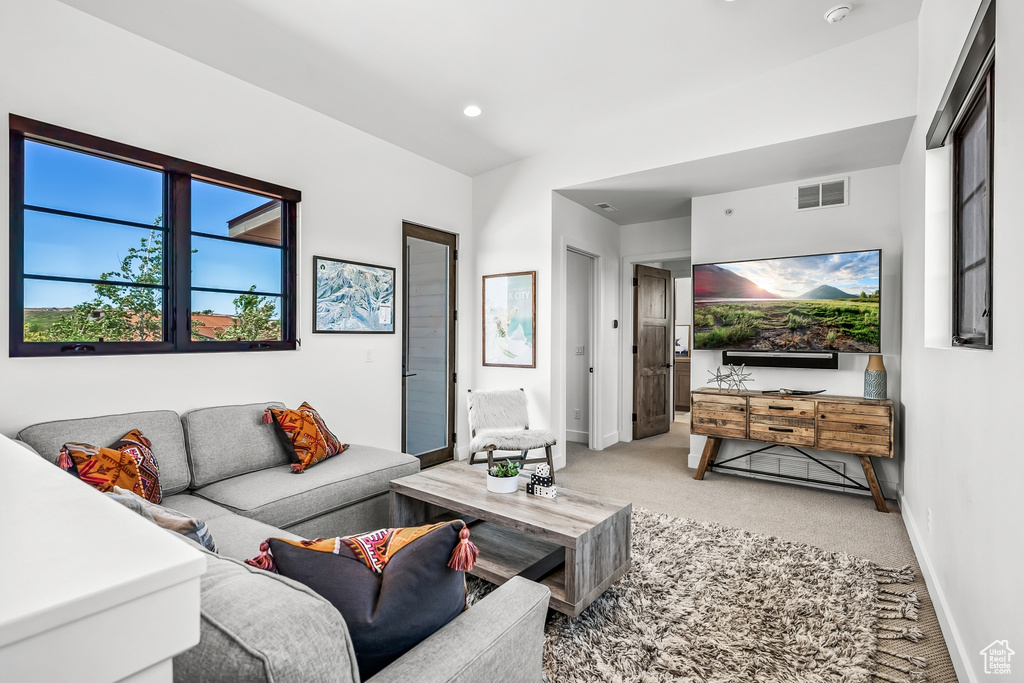 Living room featuring baseboards, visible vents, light colored carpet, and recessed lighting