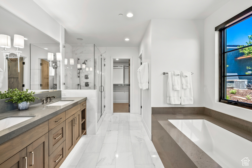 Full bathroom featuring a shower stall, a sink, recessed lighting, a garden tub, and marble finish floor
