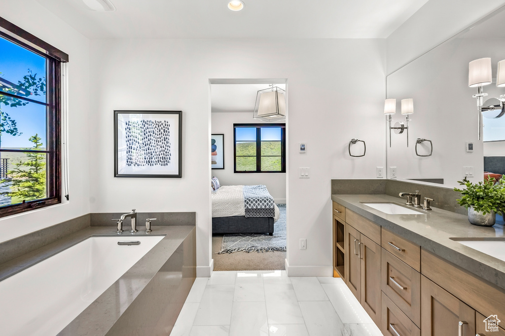Full bathroom with recessed lighting, a sink, double vanity, baseboards, and ensuite bathroom