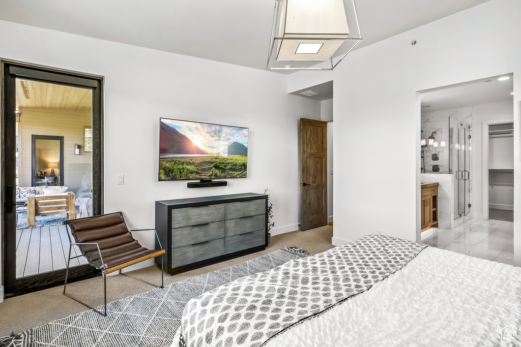 Bedroom with baseboards, ensuite bath, and carpet