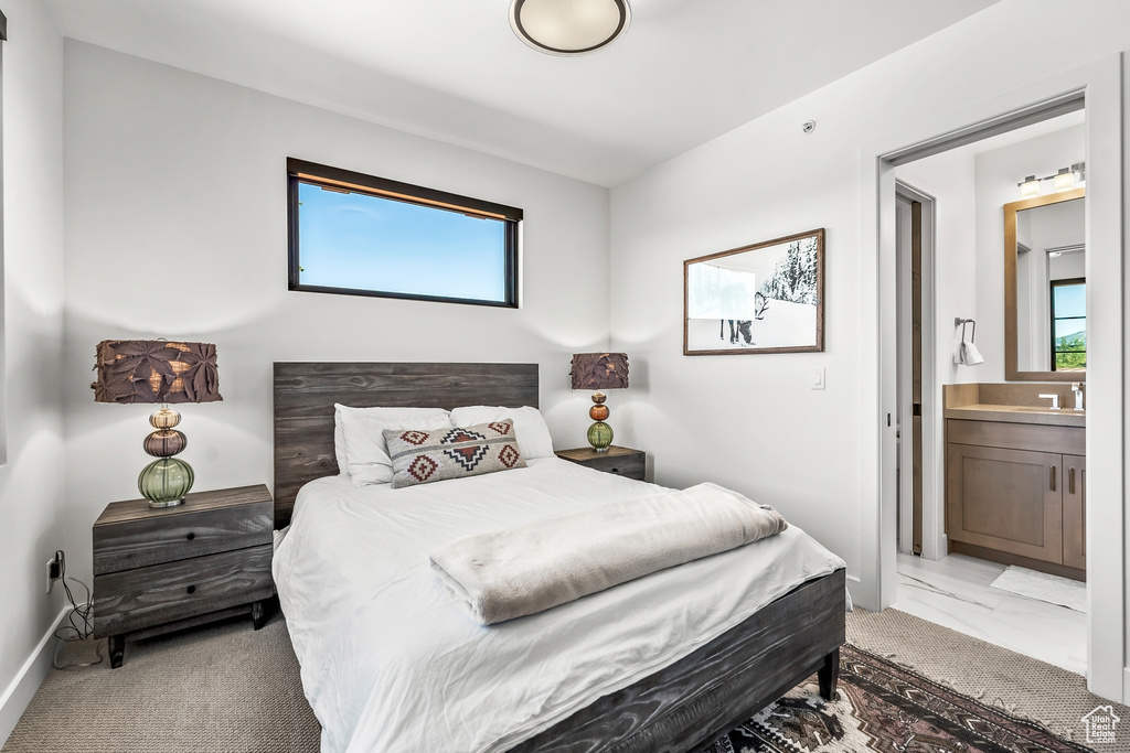 Bedroom featuring marble finish floor, a sink, and ensuite bath