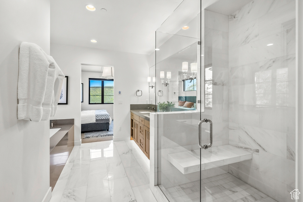 Ensuite bathroom with a shower stall, marble finish floor, ensuite bathroom, vanity, and baseboards
