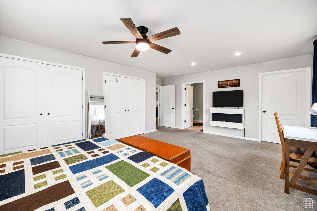 Unfurnished bedroom with multiple closets, ceiling fan, and carpet