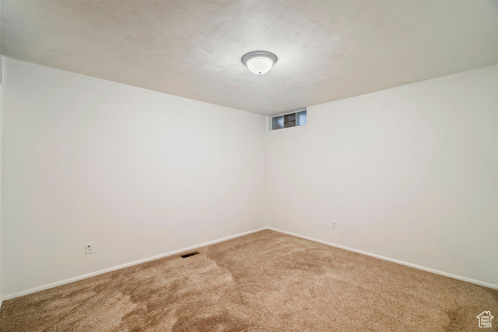 Empty room with carpet and a textured ceiling