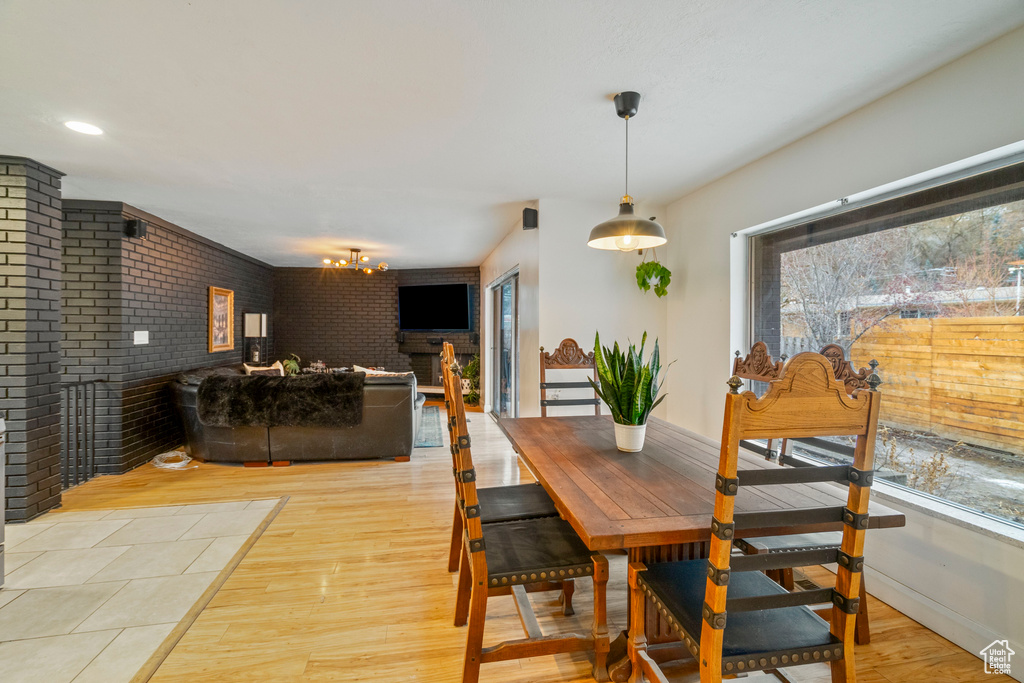 Dining area with brick wall and light wood-type flooring