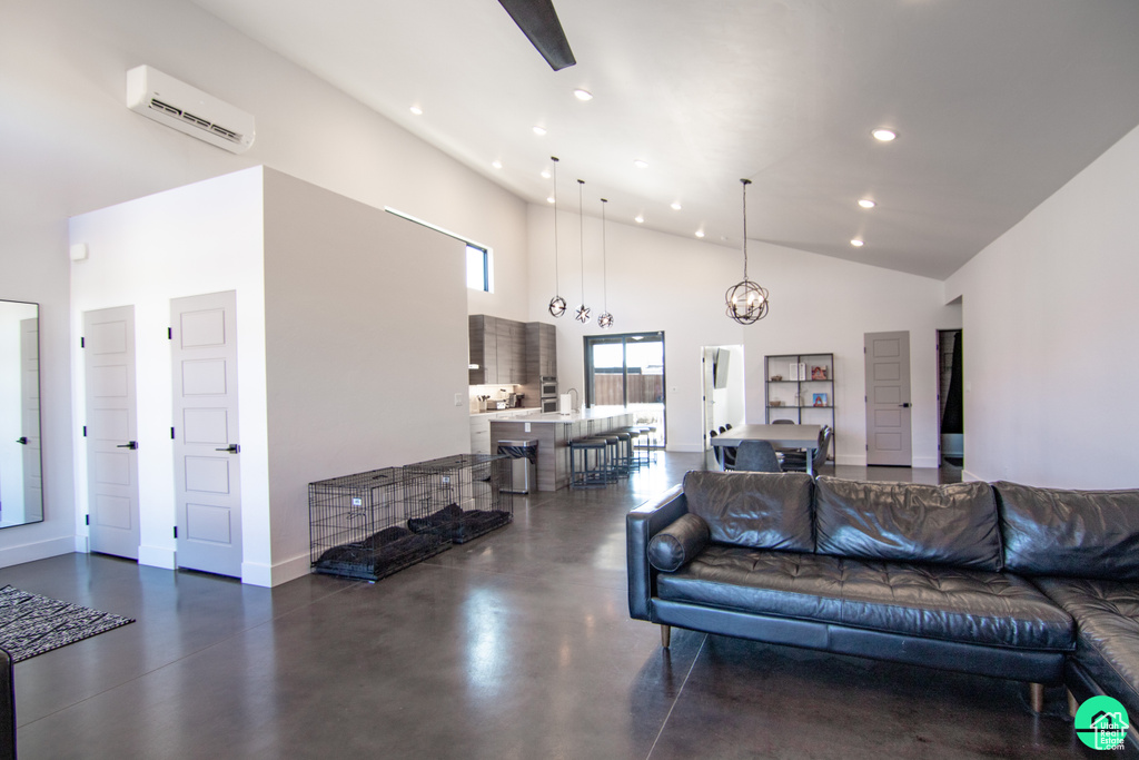 Living room with an inviting chandelier, high vaulted ceiling, and a wall unit AC