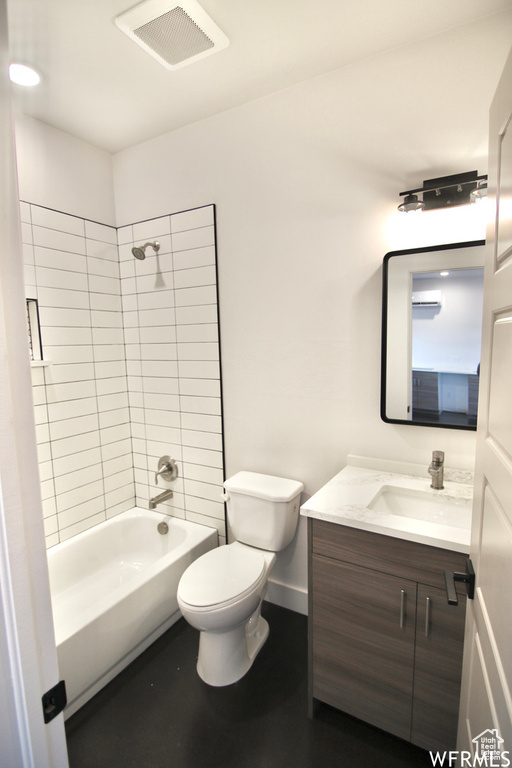 Full bathroom featuring toilet, tiled shower / bath, and vanity