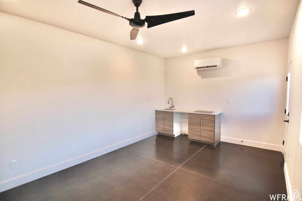 Unfurnished office featuring sink, ceiling fan, and an AC wall unit