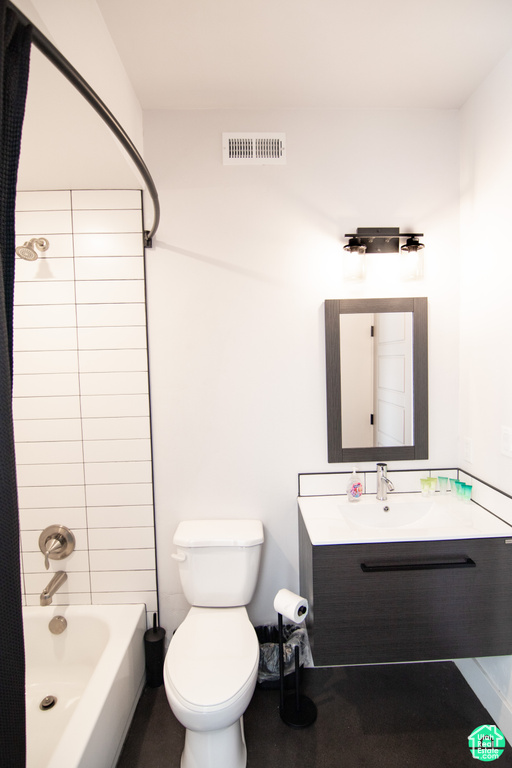 Full bathroom with vanity, tiled shower / bath combo, and toilet