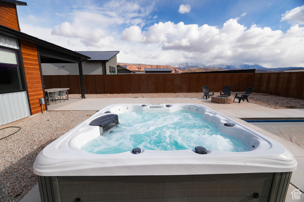 View of pool with a hot tub, a patio, and a fire pit
