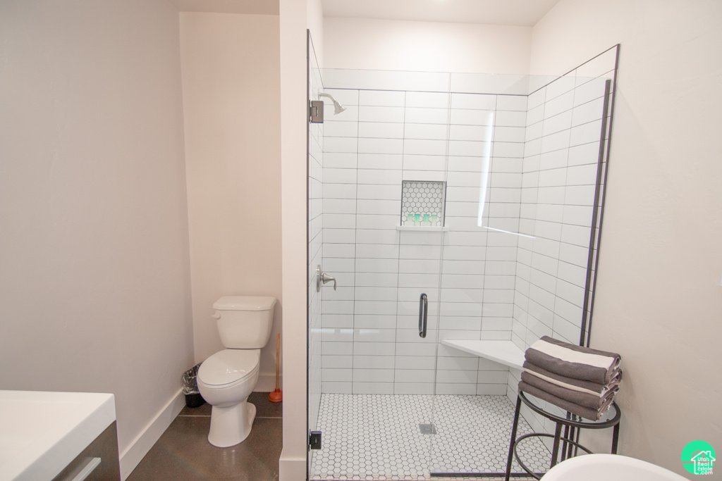 Bathroom with vanity, toilet, and a shower with shower door