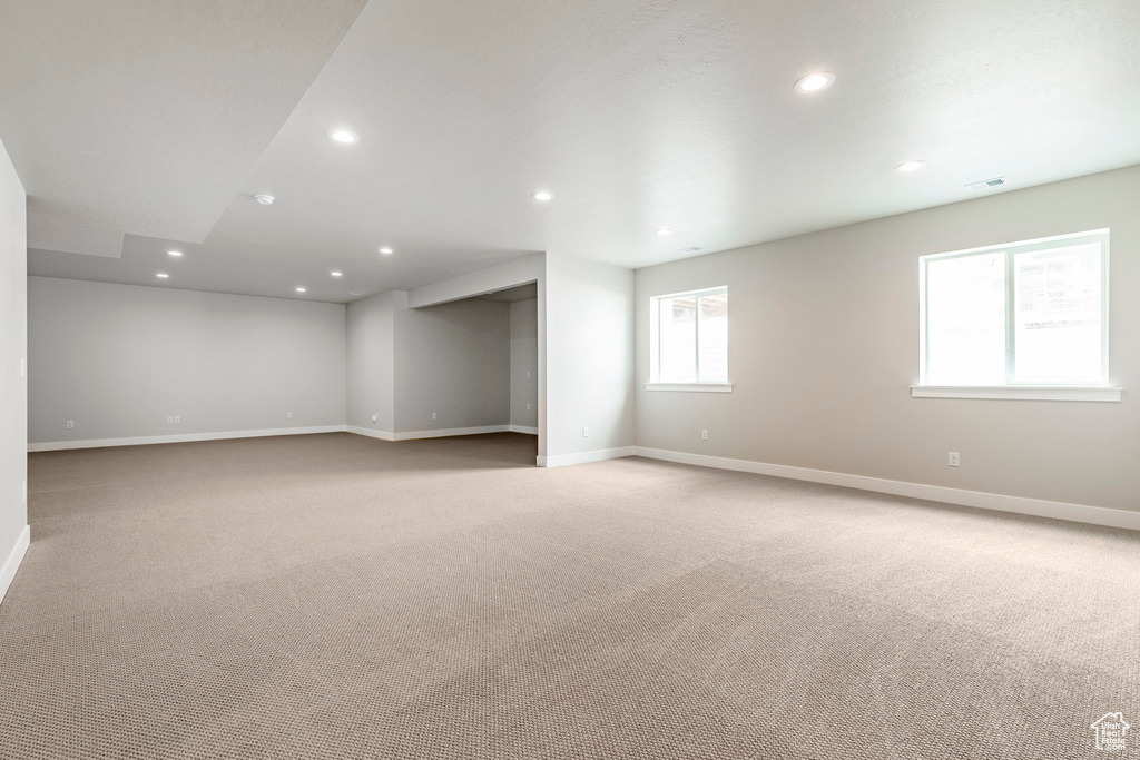 Empty room with light colored carpet, baseboards, and recessed lighting