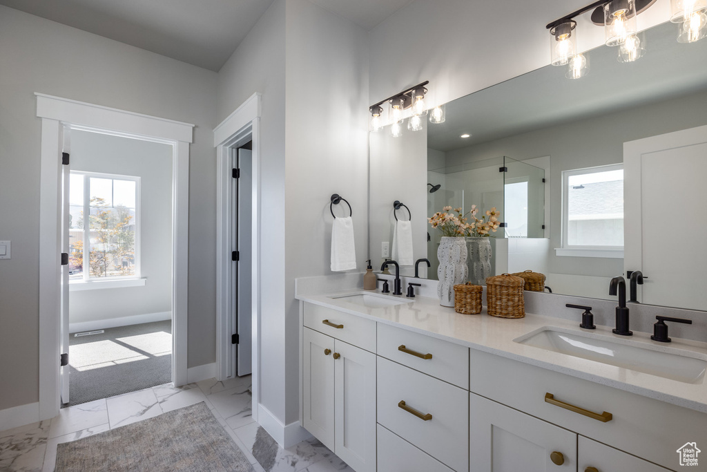 Bathroom with plenty of natural light, a shower with shower door, and baseboards